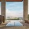 swimming pool next to a bar and cabanas with lounge chairs