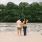 a man and woman walking on a dock by water
