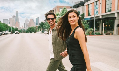 a man and woman walking across a street